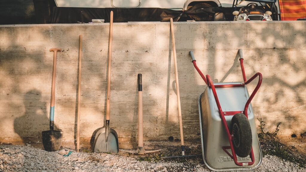 red and black shovel beside brown wooden stick